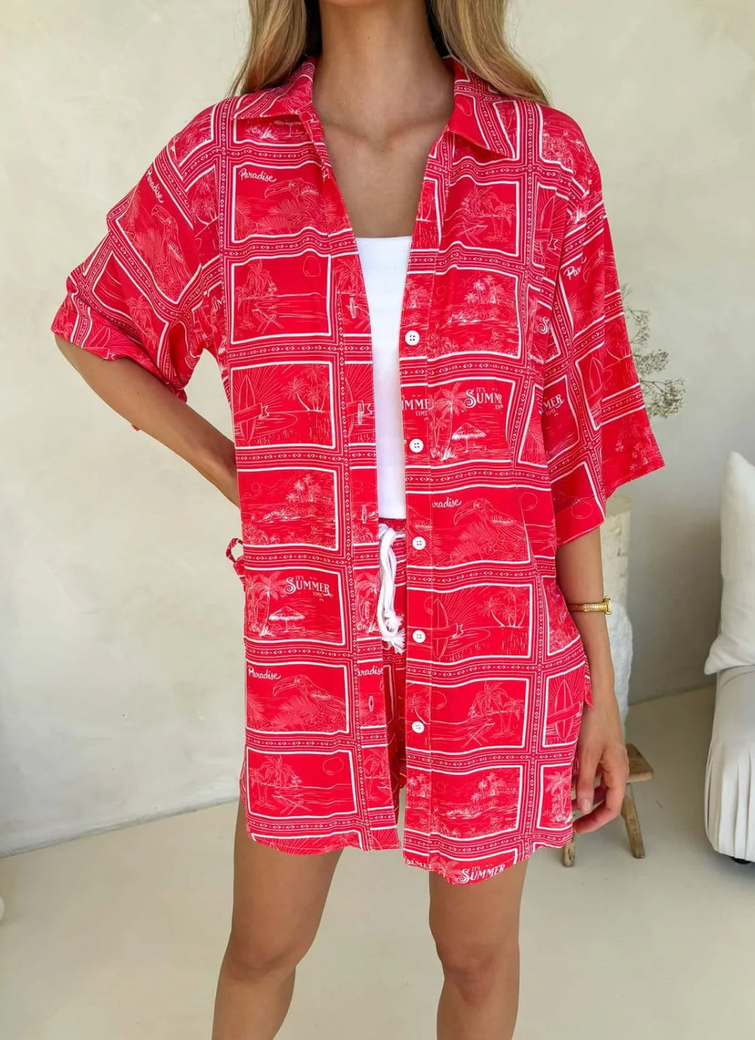 Close up Model wearing Monroe Avenue Summer Set – matching red printed shirt and shorts with white drawstring waist and bold tropical holiday print