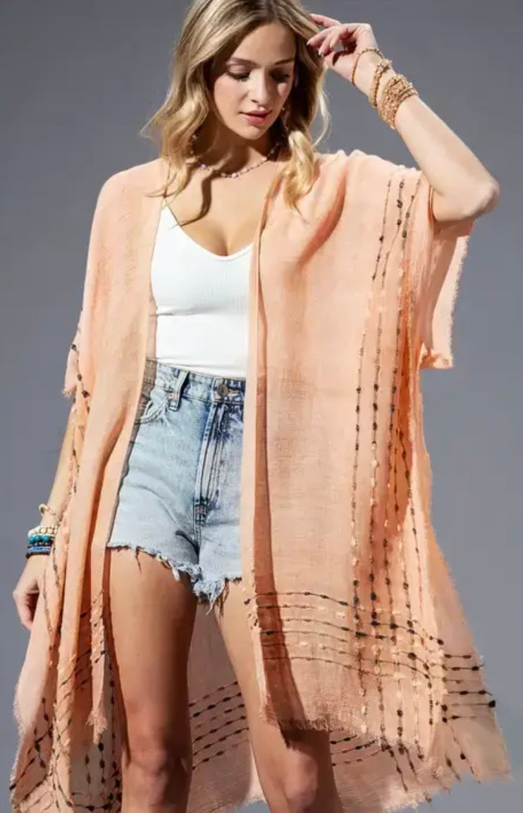 Woman wearing Coral Kimono – peach boho kimono with fringe details and summer layering style
